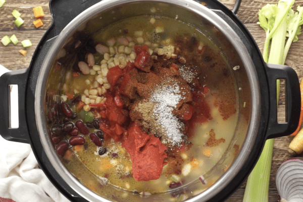 tomatoes, tomato poaste, and chili seasonings go into the Instant Pot for vegetarian chili