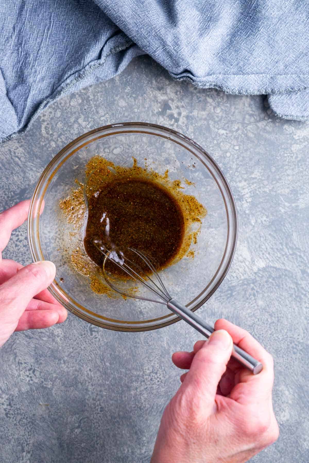 chicken wing seasoning is whisked in glass mixing bowl