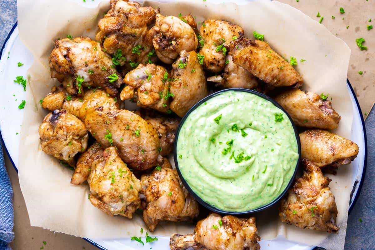 platter of baked chicken wings with nested bowl avocado ranch dressing