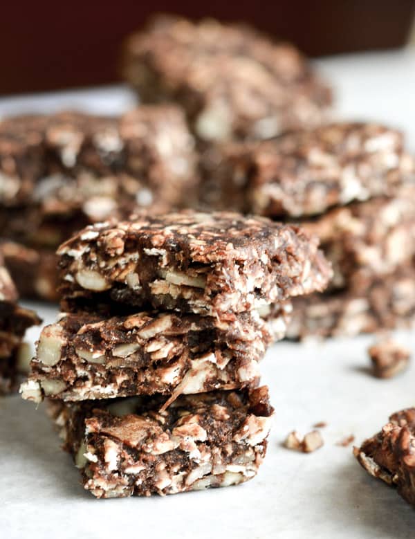 chocolate energy bar squares stacked on parchment paper