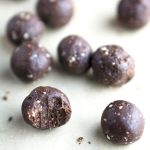 chocolate energy bites scattered on off-white background
