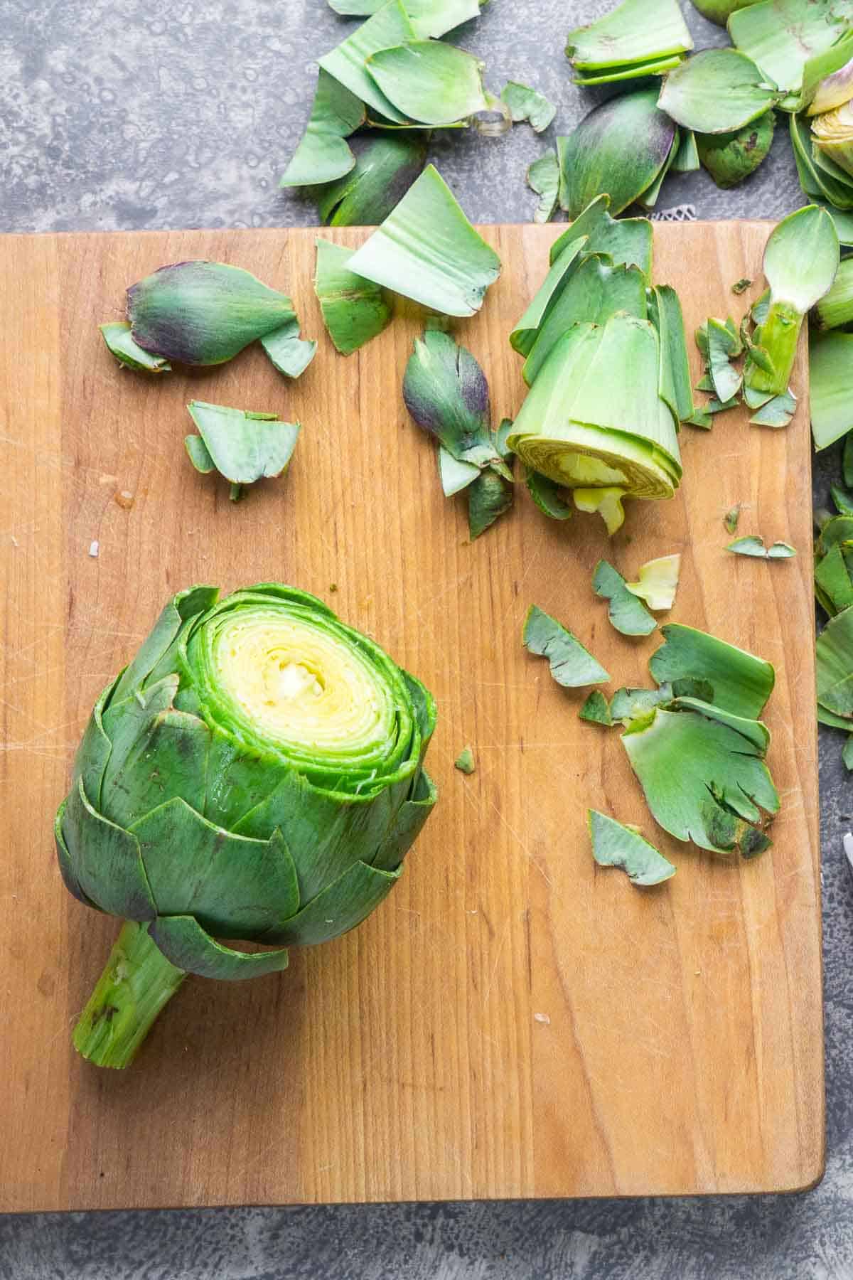 trimmed whole artichoke on cutting board