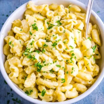 mac and cheese in white bowl on blue background