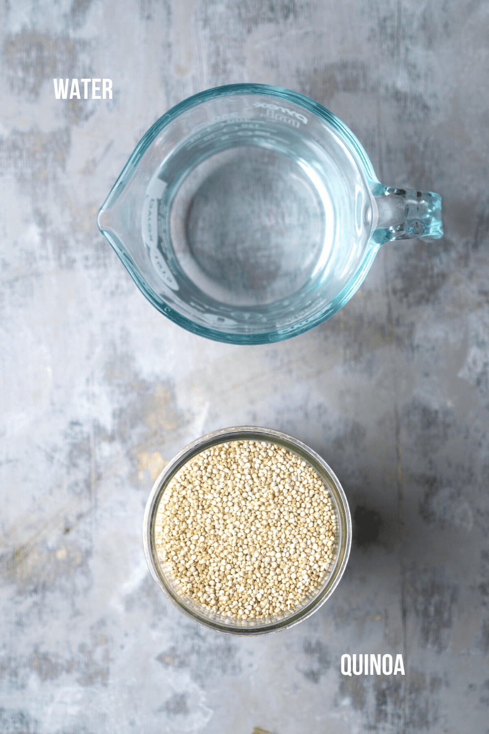 dry quinoa in glass jar next to water in glass measure cup