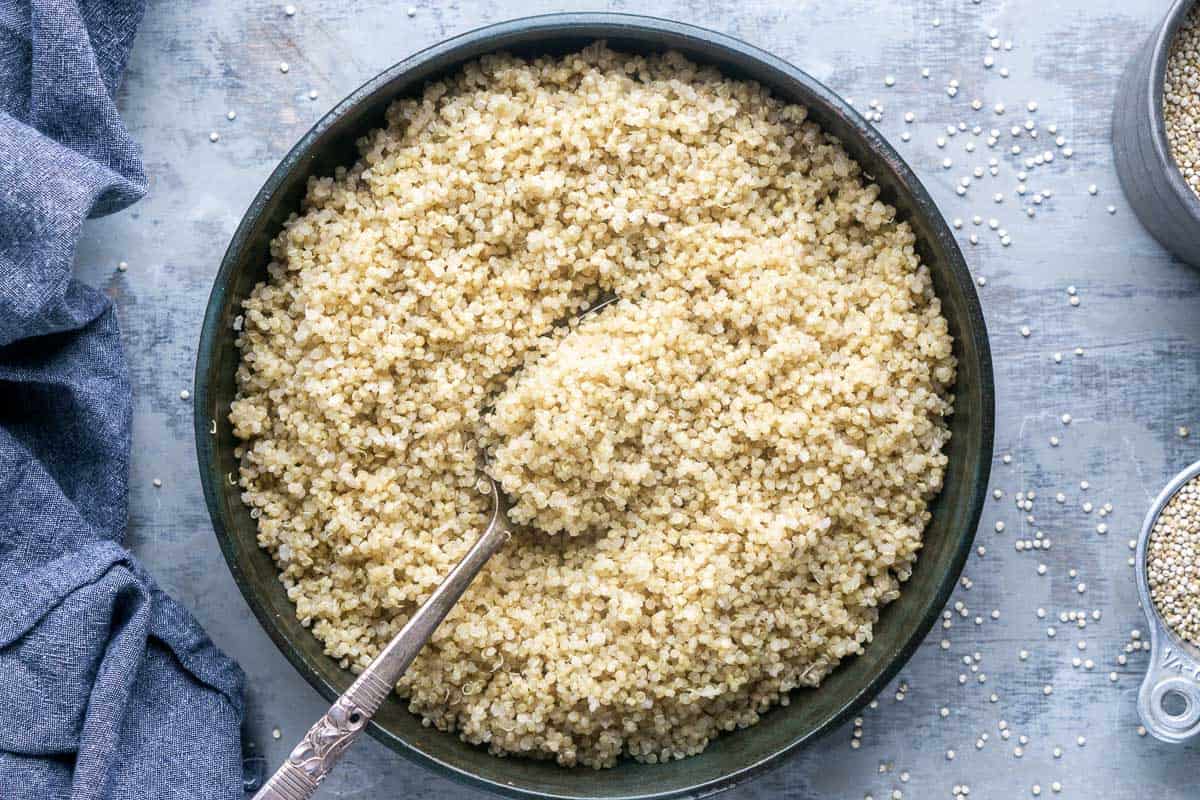 cooked quinoa in ceramic serving bowl with serving spoon