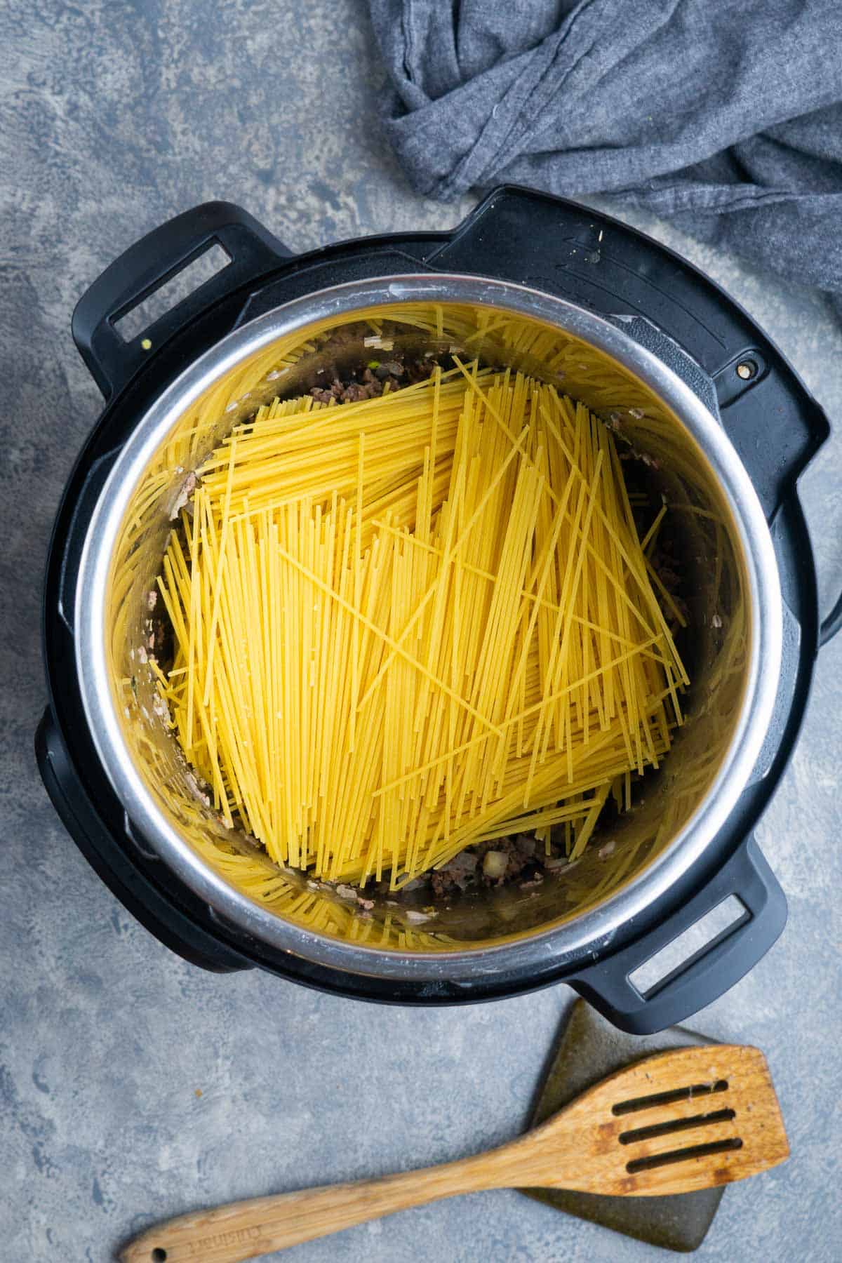 dry spaghetti noodles stacked criss cross in the instant pot