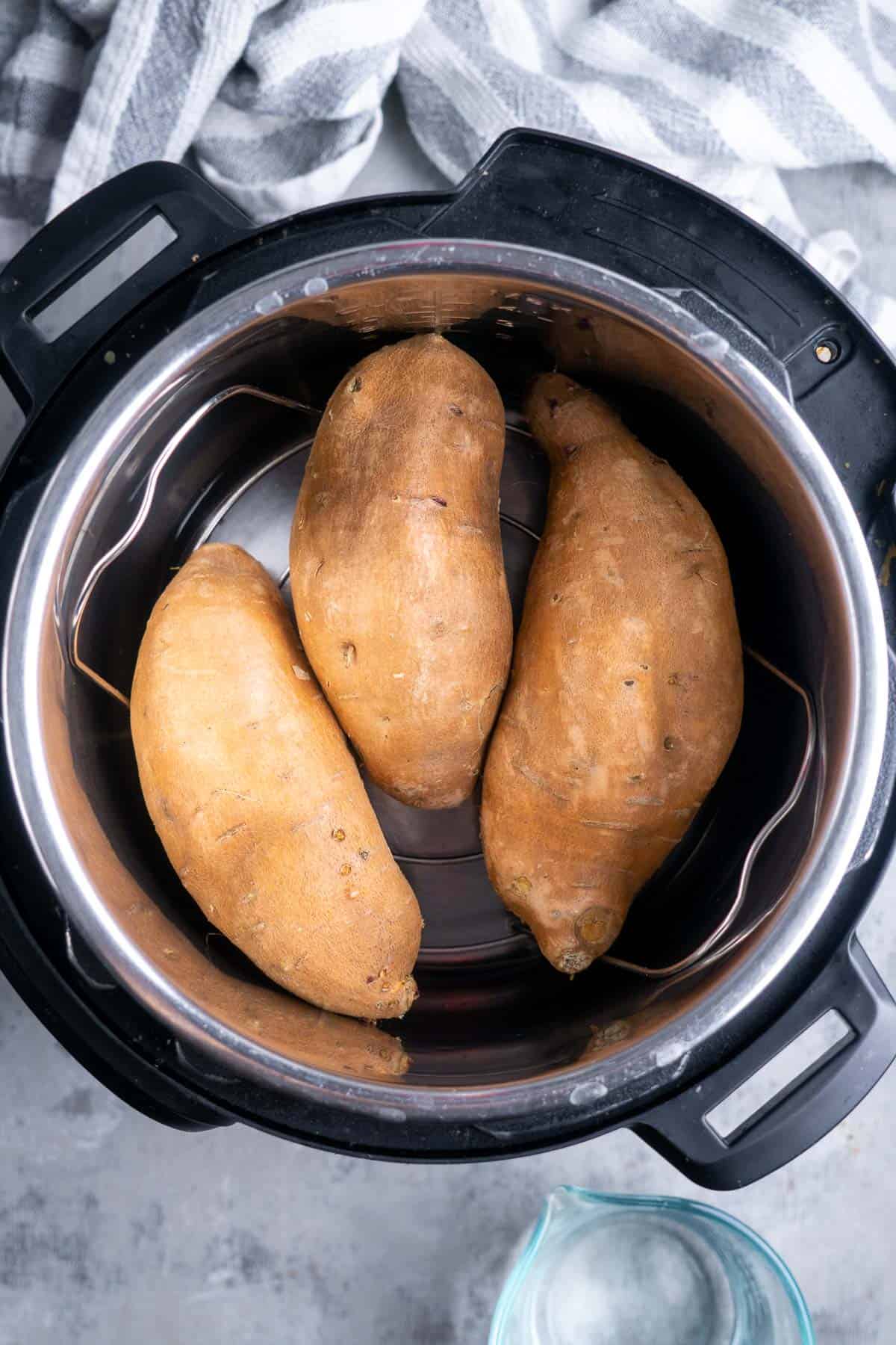 Three sweet potatoes on a trivet in the instant pot