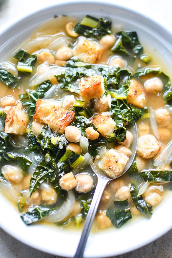 kale chickpea soup in white bowl with spoon