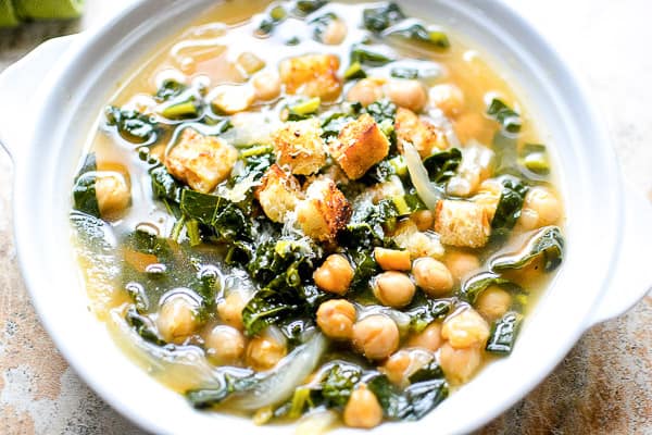 kale chickpea soup in white bowl on marble background