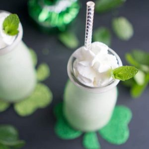 green Shamrock shakes in milk bottle jars with straw and St. Patrick's day decorations
