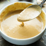 spoonful of peanut sauce in white bowl
