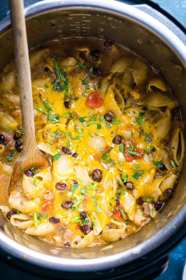 cheesy taco pasta in the Instant Pot with wooden spoon