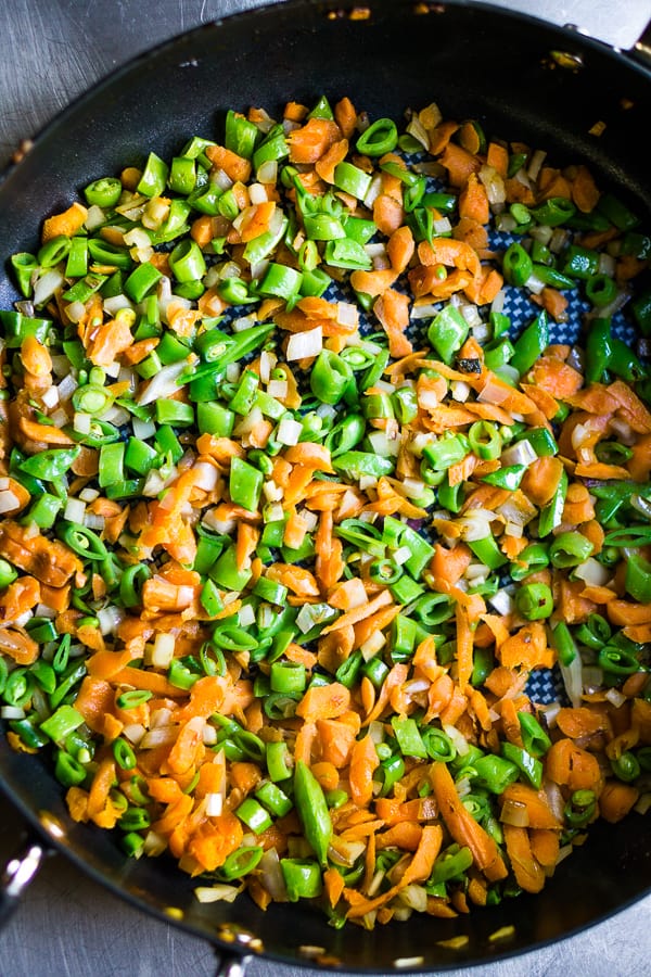 chopped carrots, onions, and snap peas in skillet