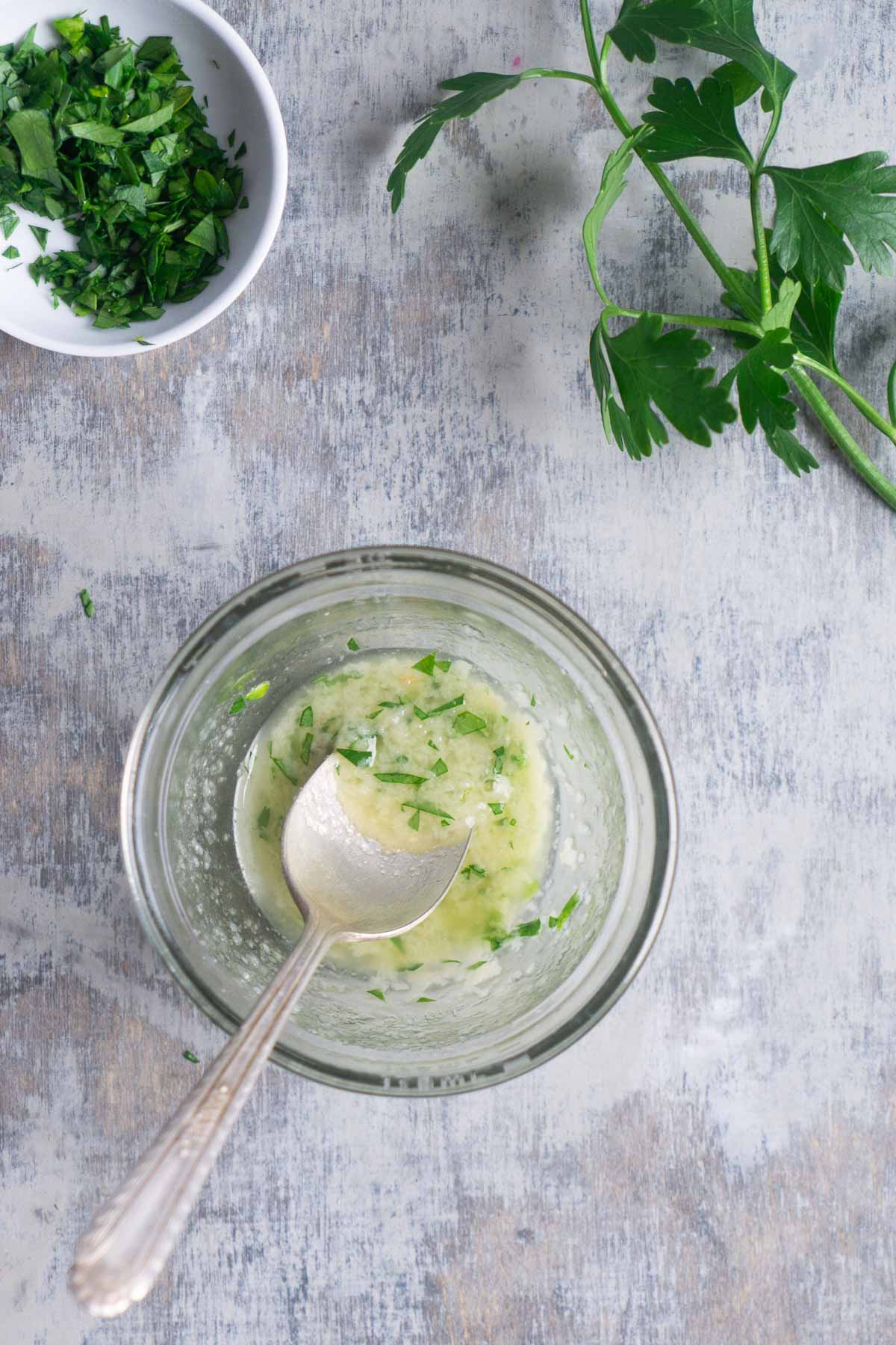 Garlic butter sauce in glass bowl with spoon