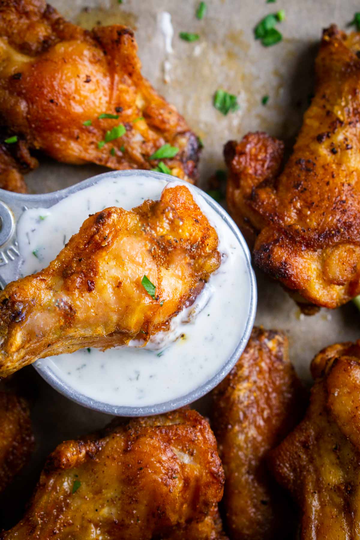 crispy baked chicken wings with ranch dressing on parchment paper