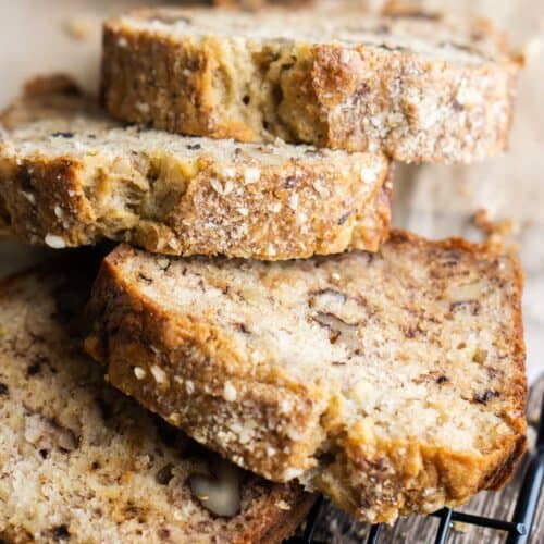 thick banana bread slices stacked up on cooling rack