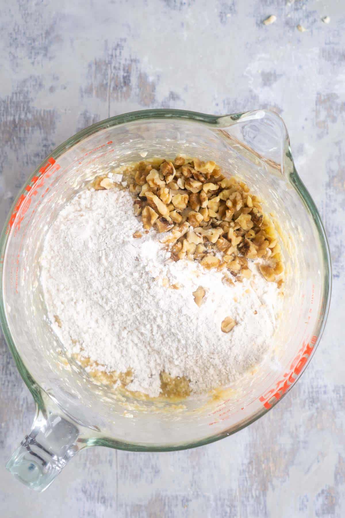 flour and chopped walnuts in glass mixing bowl