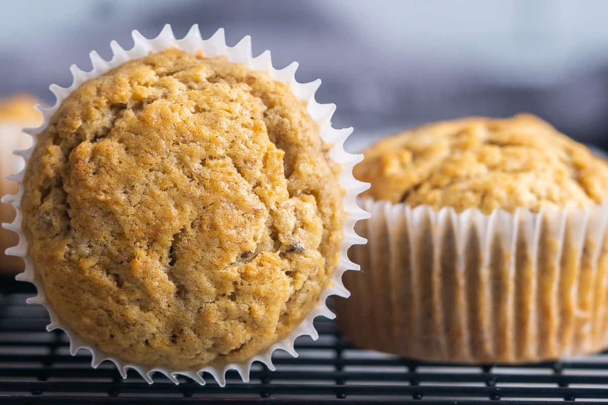 baked banana bread muffins in cupcake liners on black cooling rack