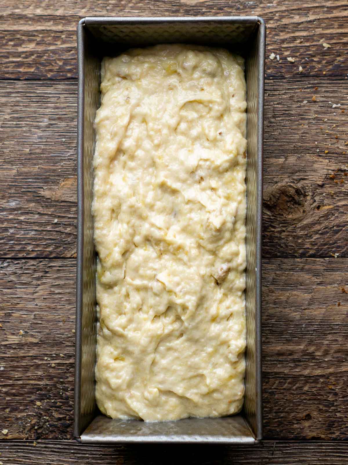 Mixed banana bread batter in a baking pan.