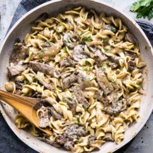 beef stroganoff in skillet with wooden serving spoon