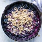 Warm blueberry crisp in iron skillet