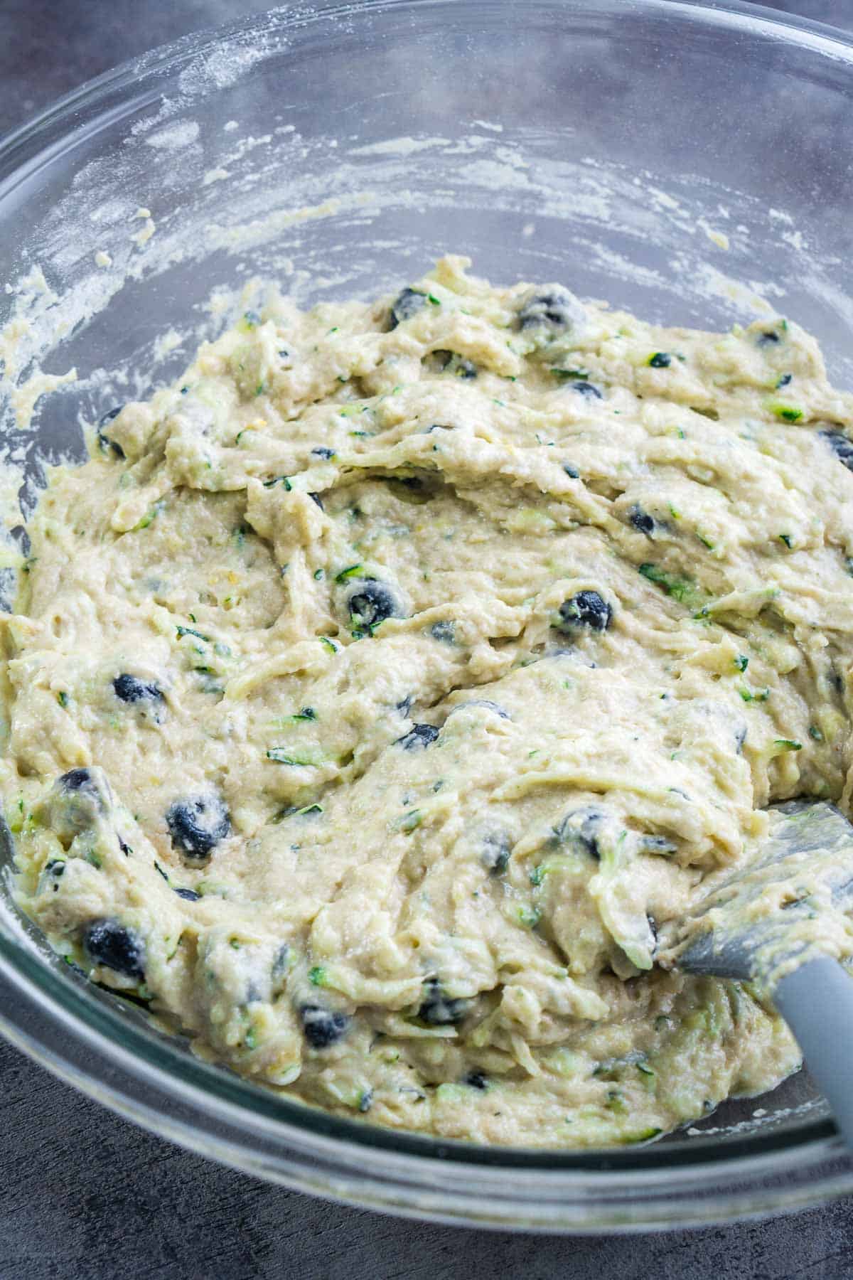 blueberries are stirred into blueberry zucchini bread batter