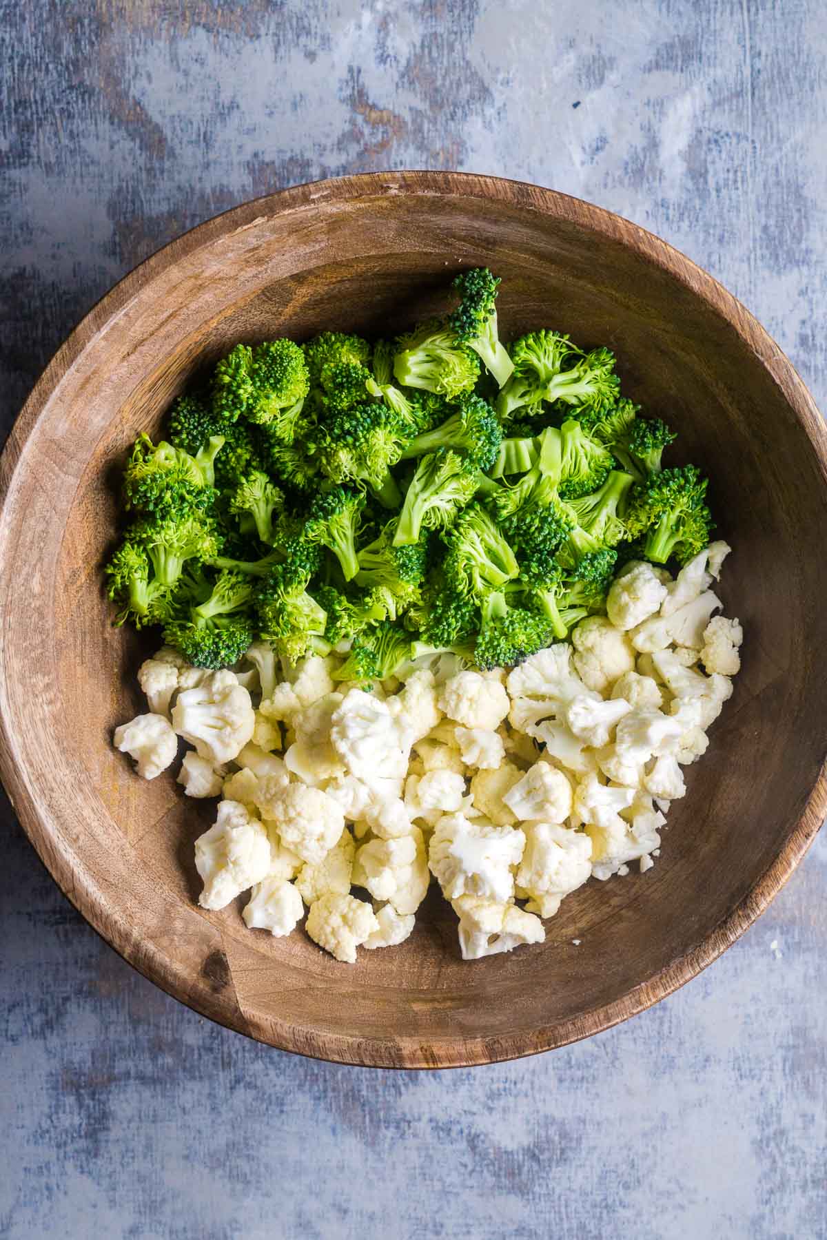 broccoli and cauliflower florets in wood bowl