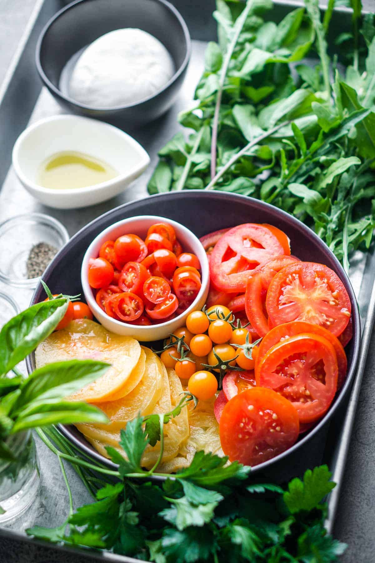 fresh ingredients for tomato burrata salad on serving tray