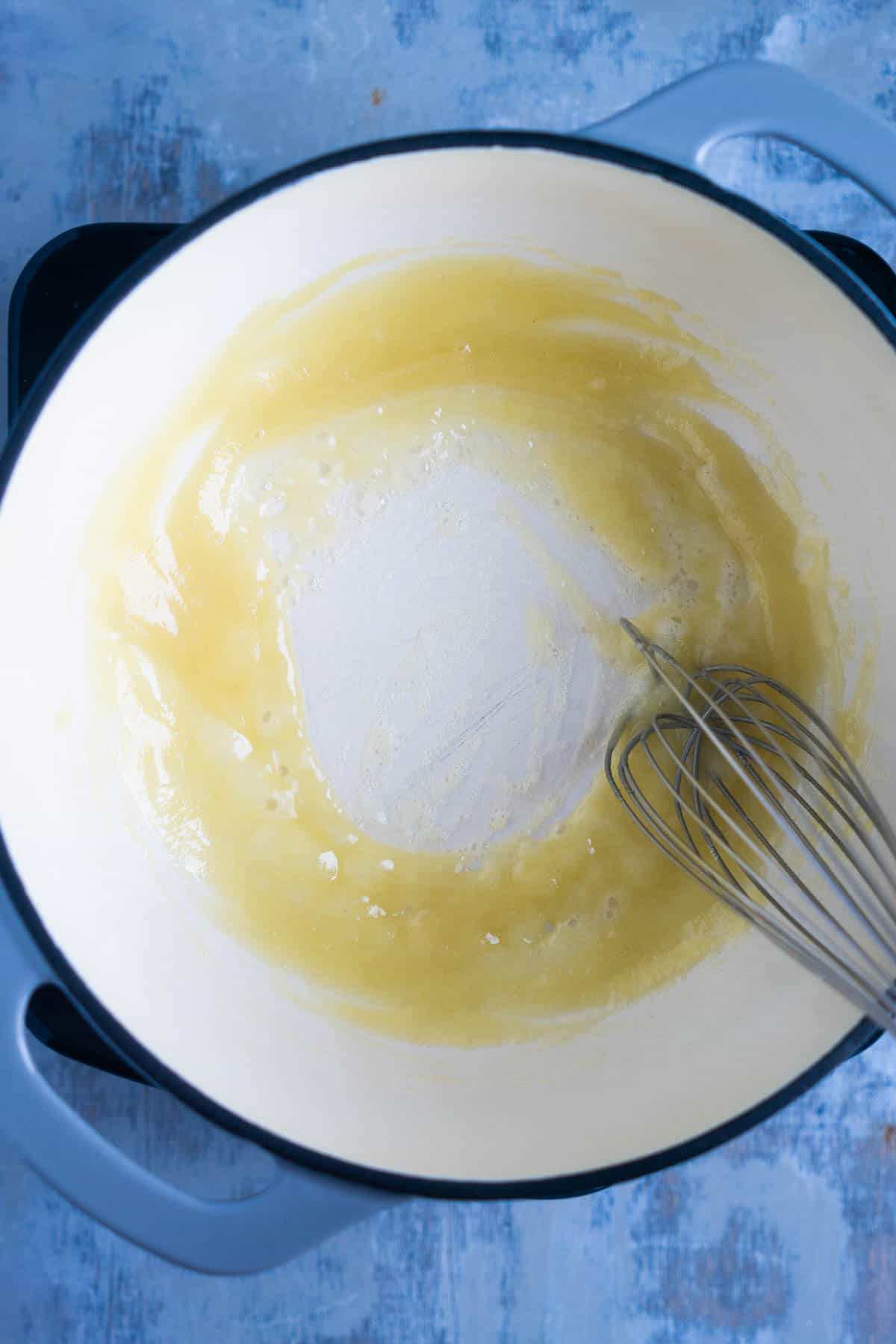 whisk stirs roux in saucepan