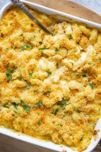 baked butternut squash mac and cheese with crispy panko topping in white baking dish with serving spoon