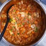 cabbage roll soup in pot with black serving spoon