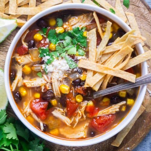 chicken tortilla soup in white bowl with spoon