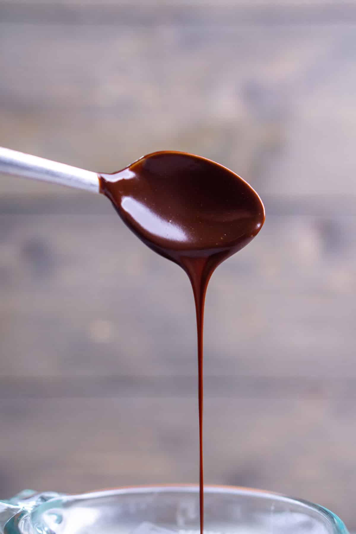 melted chocolate dripping from spoon in a solid stream