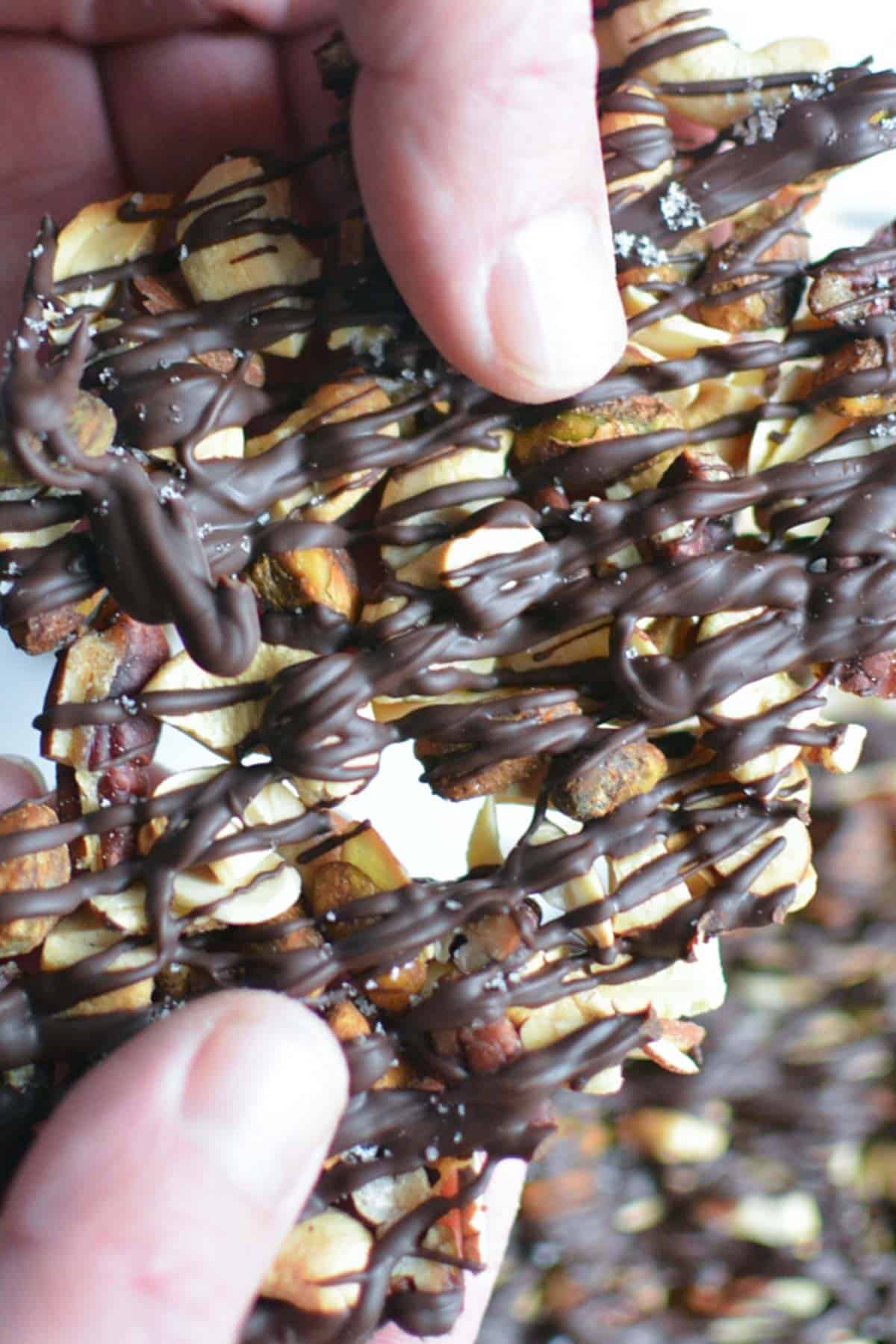 Persons hands breaking chocolate covered nuts into clusters