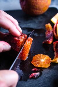 blood orange is being sliced with chef's knfe