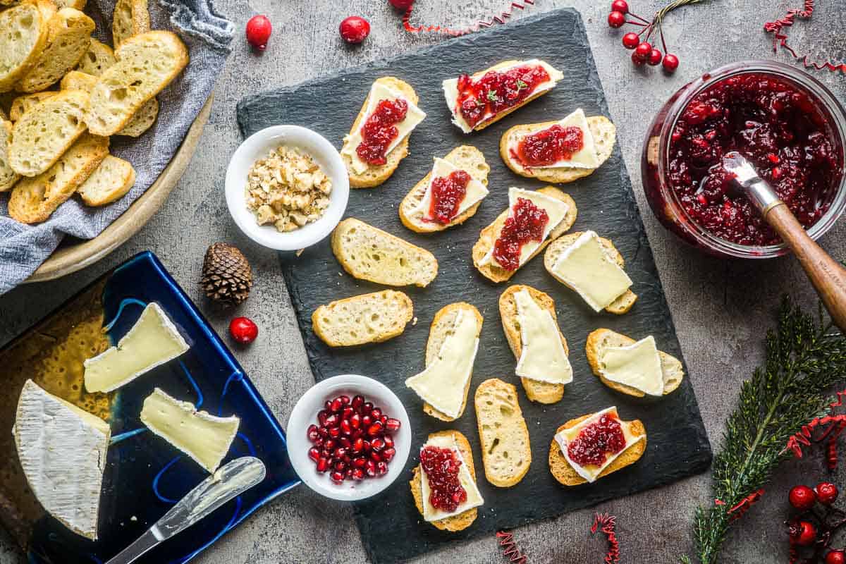 cranberry brie crostini appetizers are assembled on slate serving tile