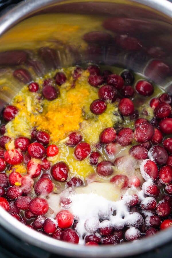 Cranberries, orange juice, orange zest, and sugar in a pot for cranberry sauce
