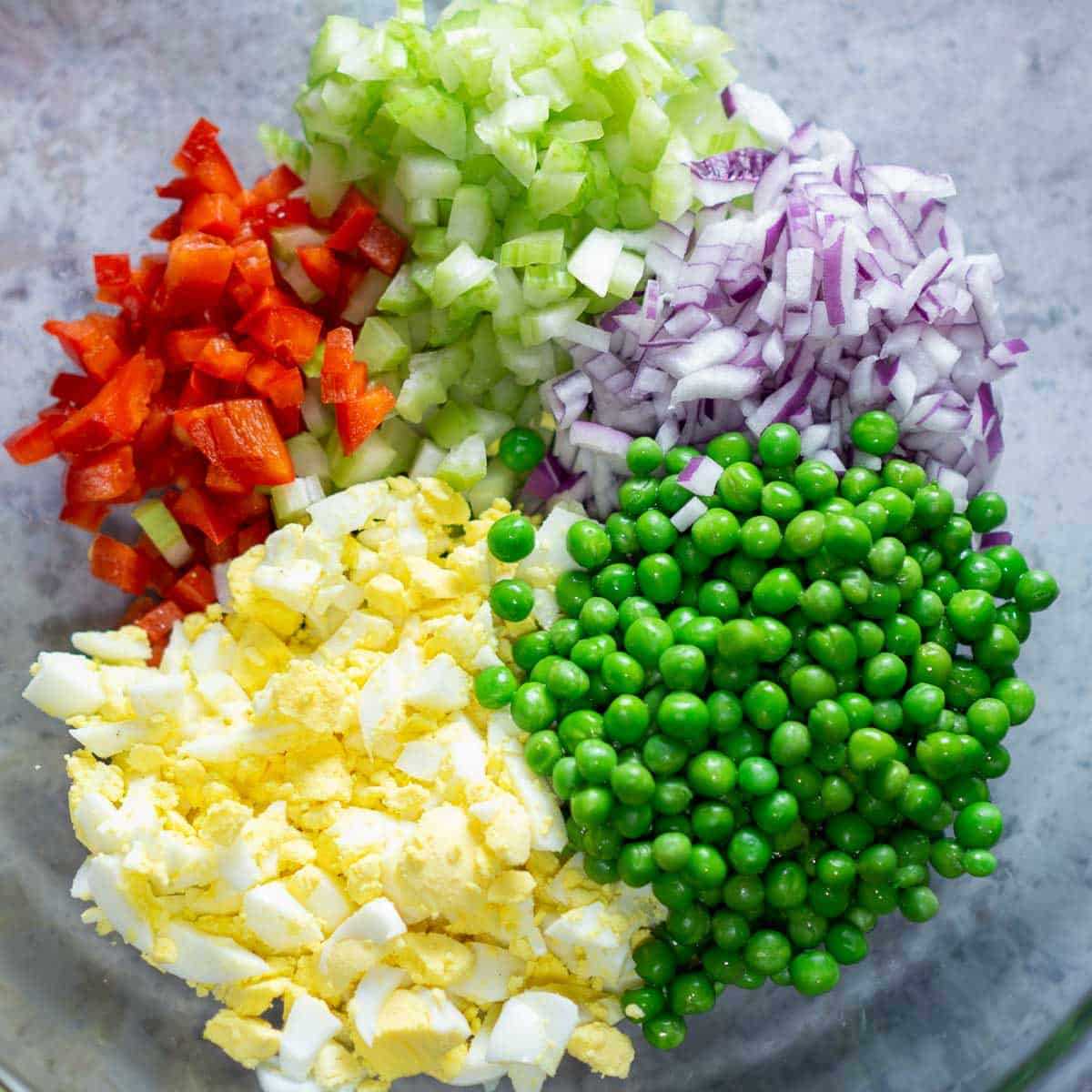 macaroni salad ingredients in glass mixing bowl