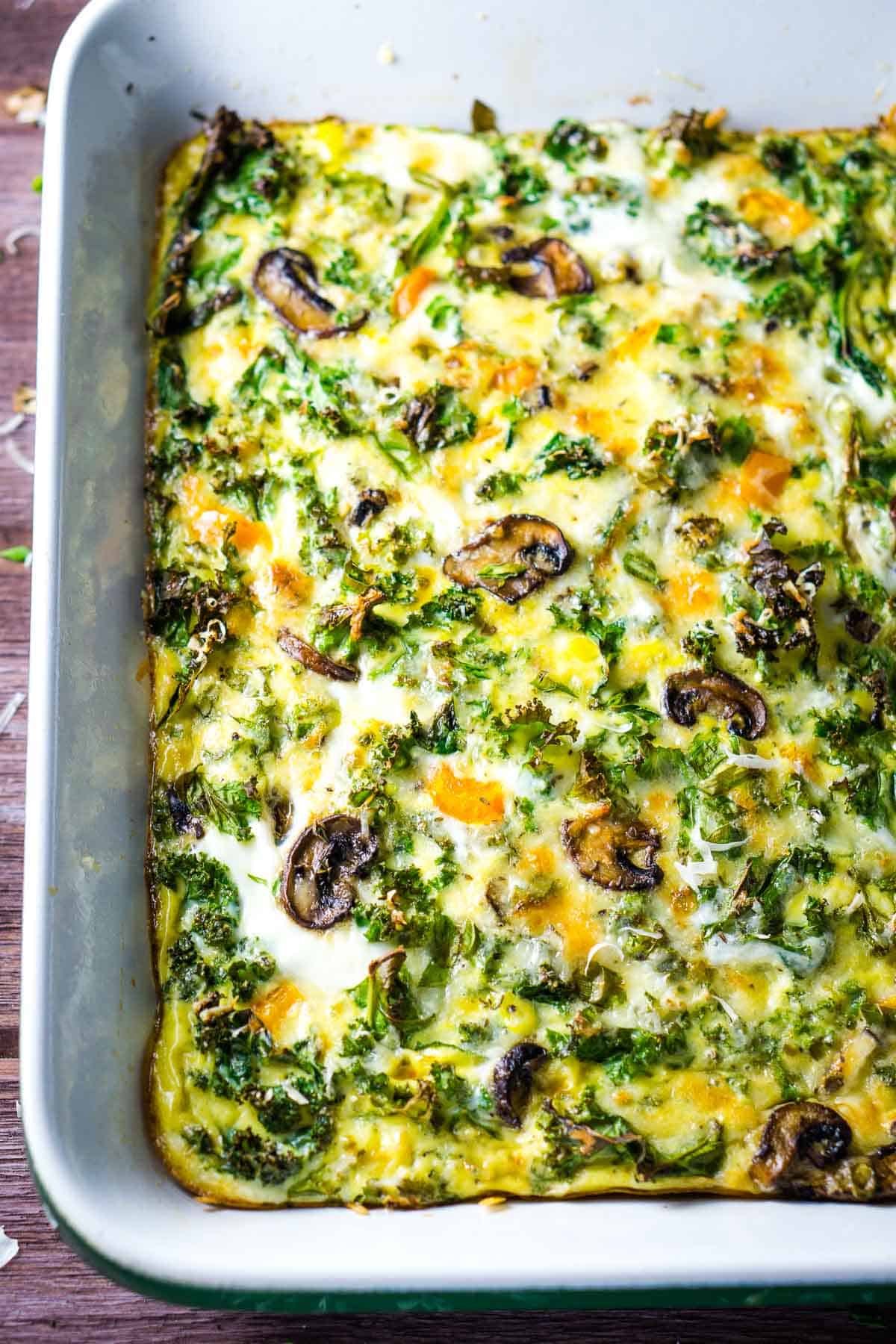 whole baked crustless vegetable quiche in white baking dish