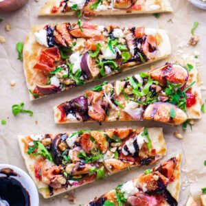 fig prosciutto flatbread pizza slices on parchment paper