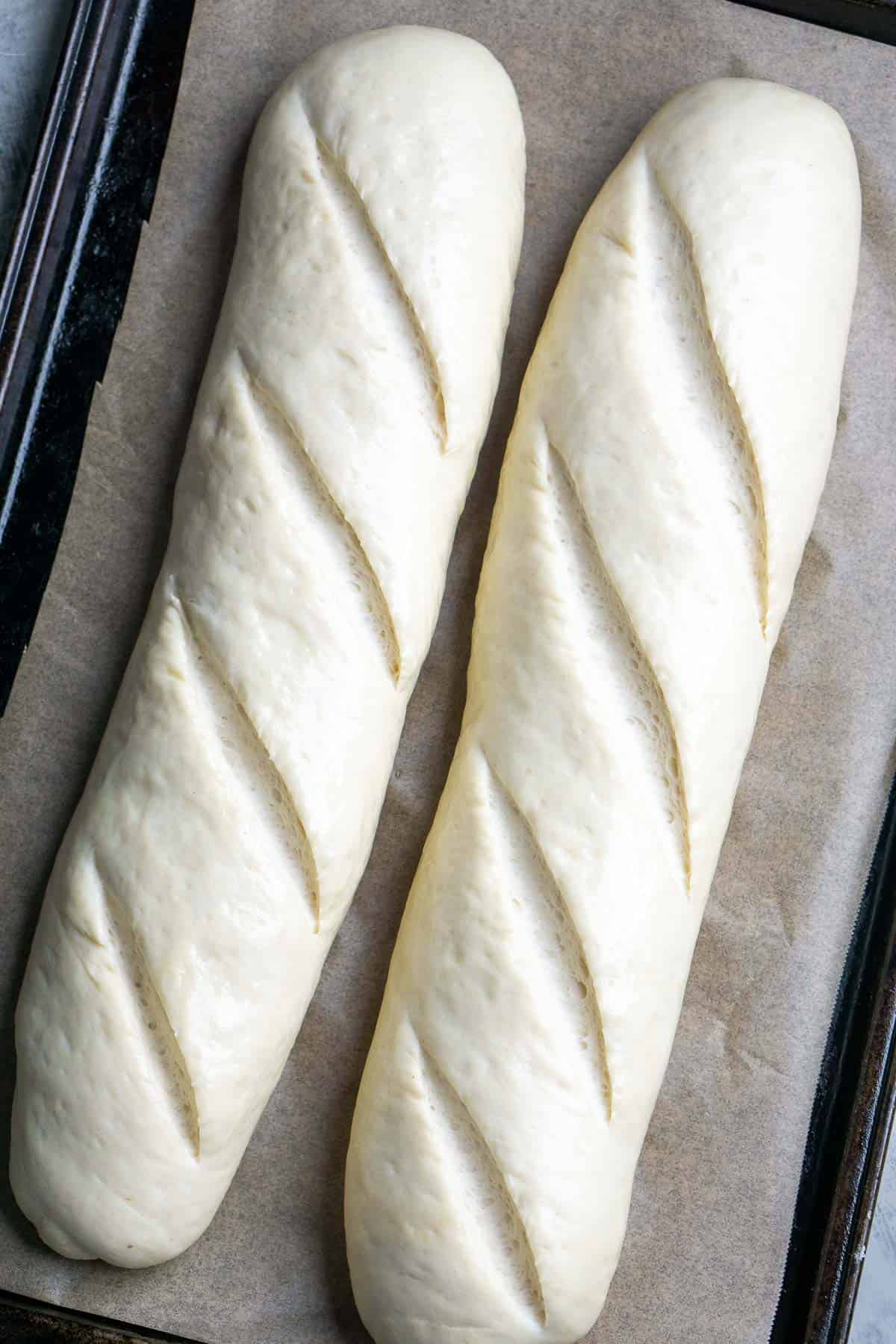 2 unbakd French loaves on parchment lined baking sheet