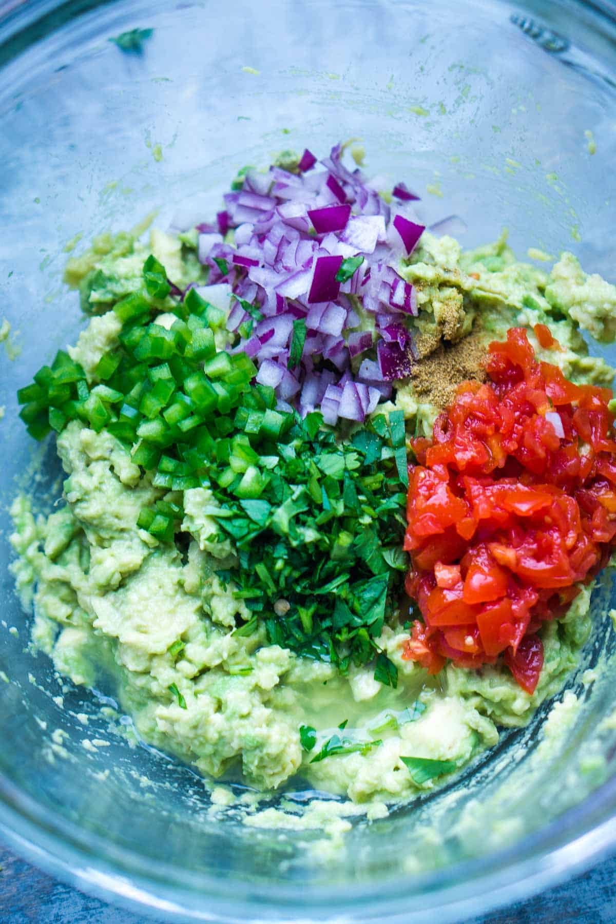 guacamole ingredients in glass mixing bowl