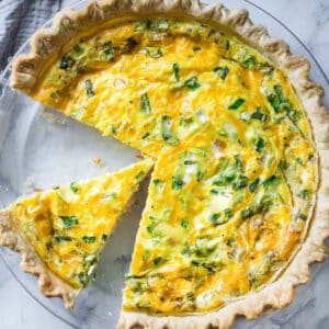 Ham and cheese quiche on glass pie plate.