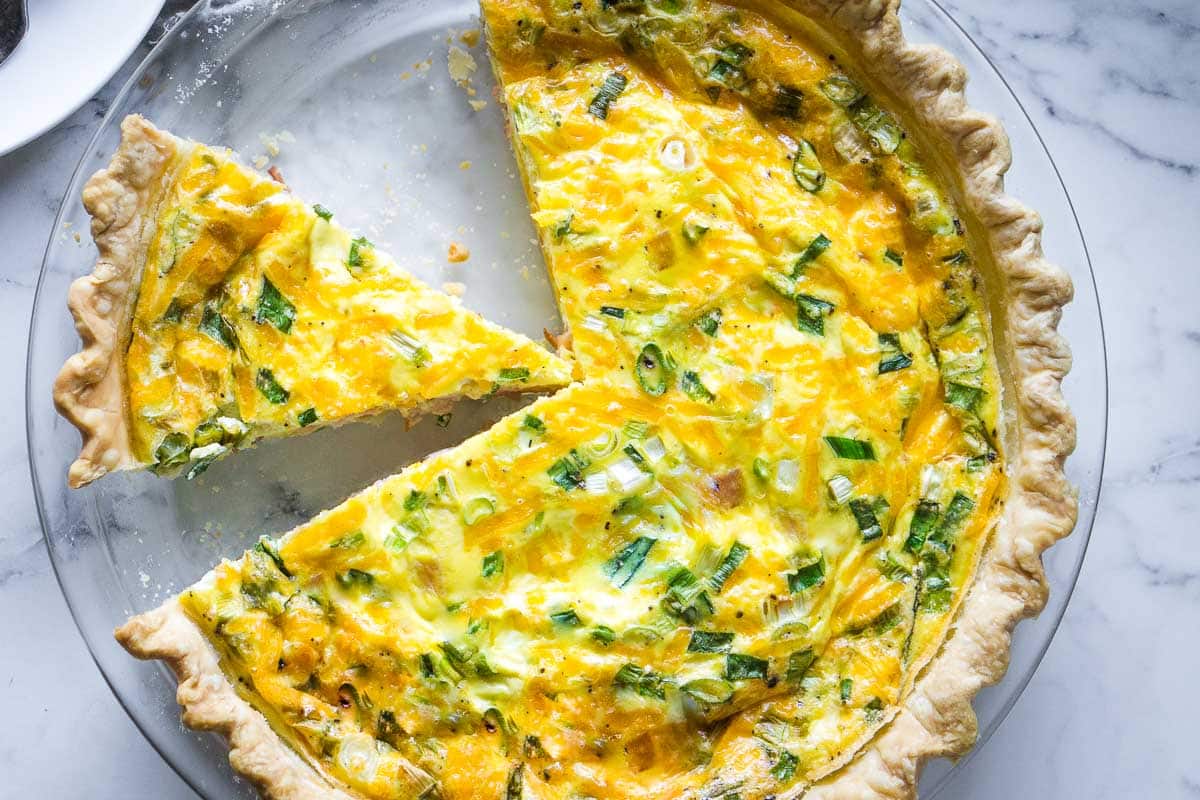 Ham and cheese quiche on glass pie plate.