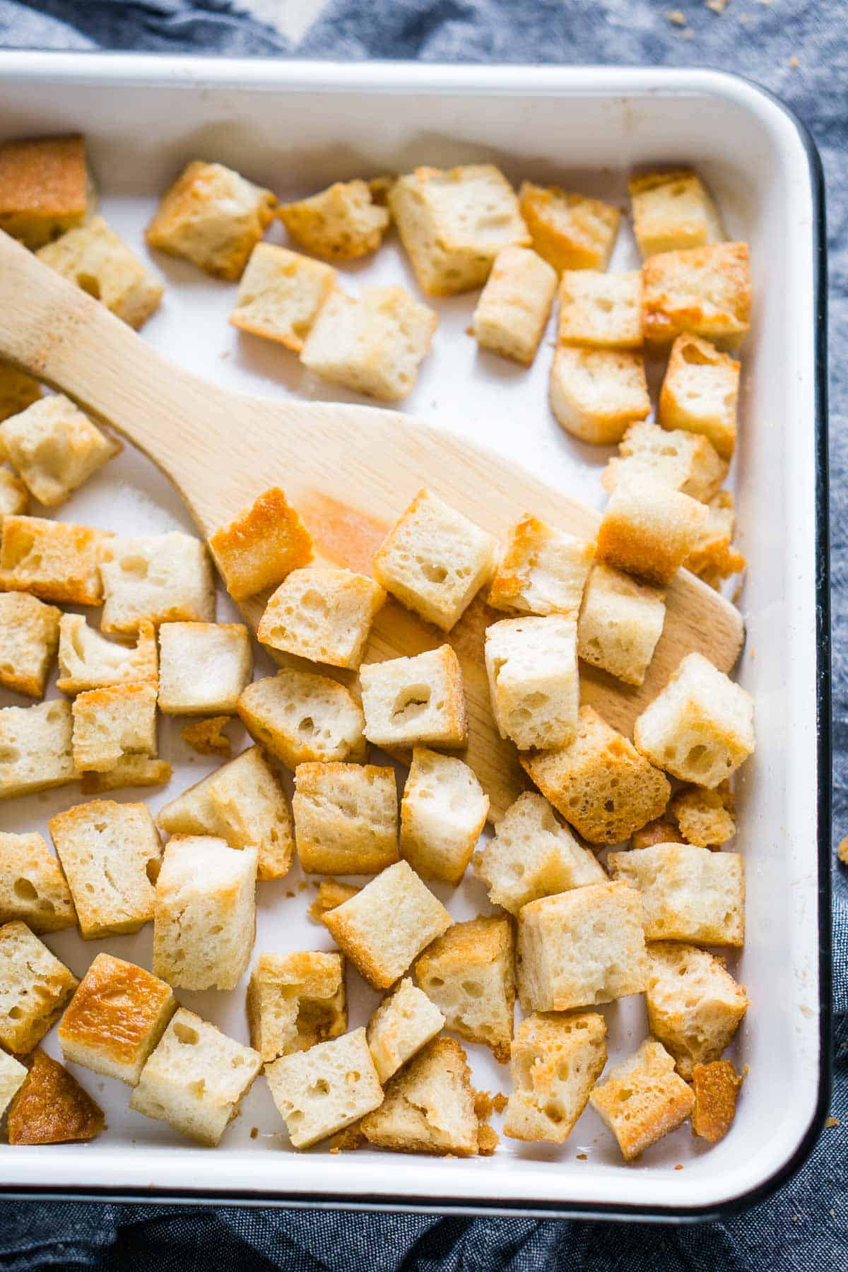 croutons on white baking sheet with wooden spatula