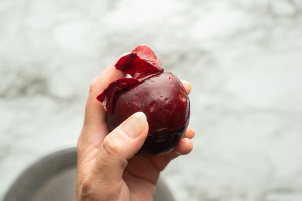 beet with skin peeling off by hand