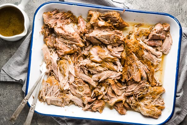 pulled pork with two forks on white tray