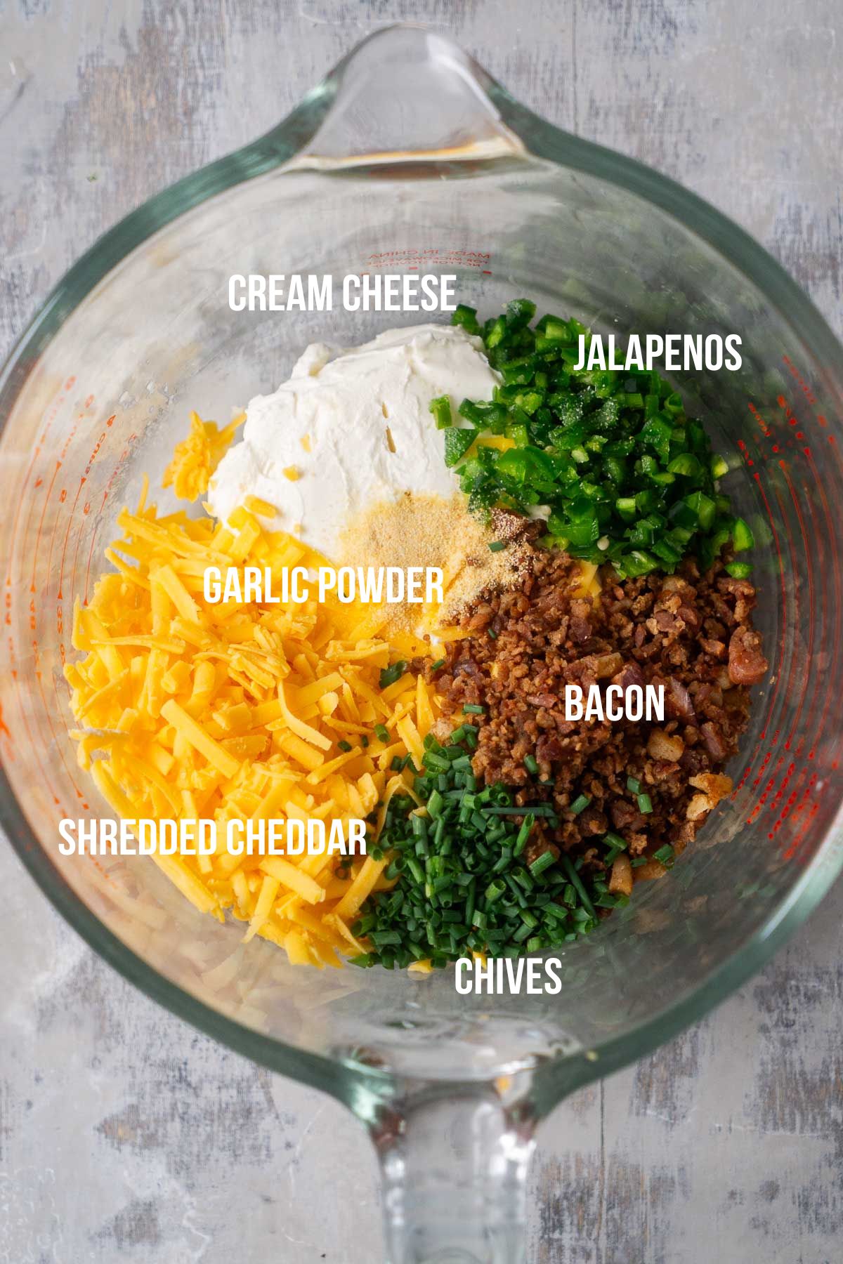 jalapeno popper cheese ball ingredients in glass mixing bowl with text overlay labels