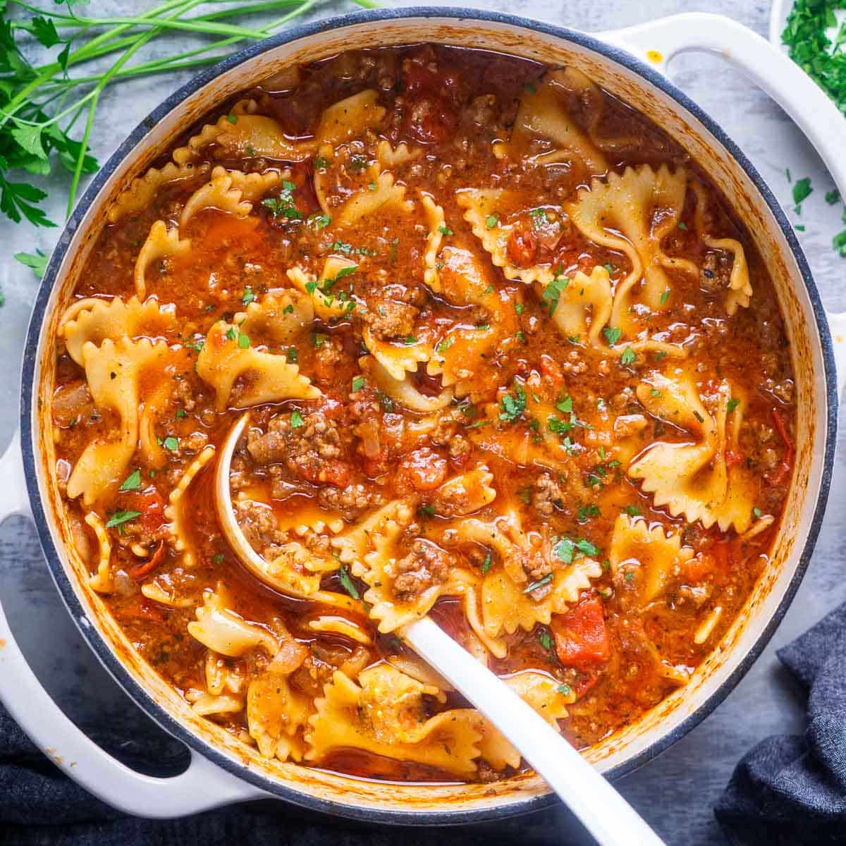 lasagna soup in Dutch oven with white ladle