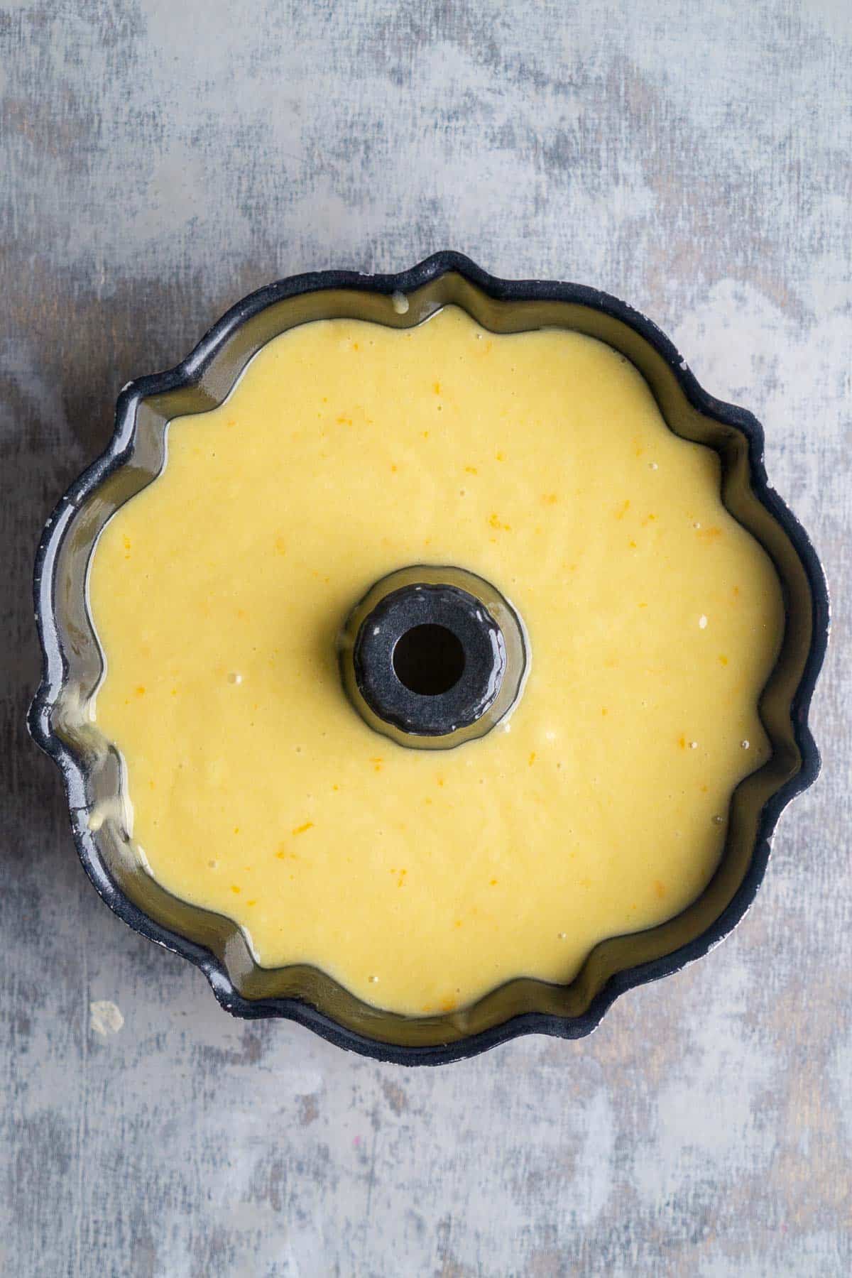 Orange olive oil cake batter in a bundt cake pan.